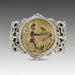 A silver ring featuring a hand-carved cherub design in a circular pattern, set against a gray background.