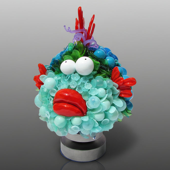 Colorful sculpture resembling a character with a round base on a gray background