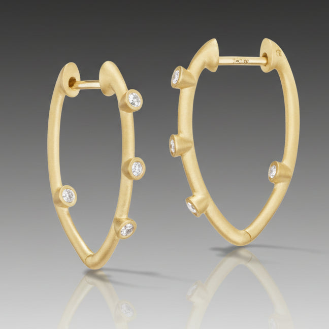 A pair of 18k gold hoop earrings with brilliant cut diamonds set within the hoops.