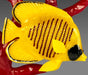 Yellow fish figurine with black stripes on a gray background