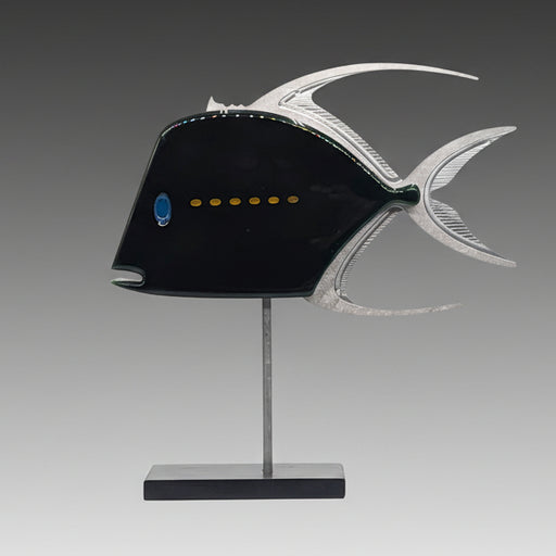 A mixed media sculpture of a fish with a predominantly black body, featuring a yellow dot stripe, silver fins, and a blue eye detail, displayed on a metal stand.