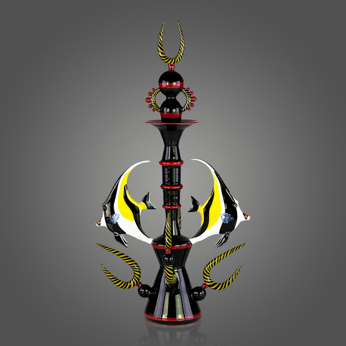 Decorative sculpture with a central pole, fish figures, and decorative elements on a gray background