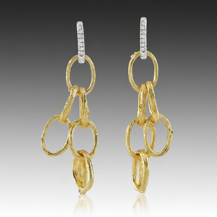 Gold chain earrings on a gray background