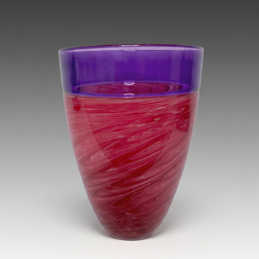 A blown glass vase with a pink and purple swirled pattern and an incalmo rim.