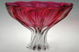 Glass bowl with red interior and clear base on a gray background