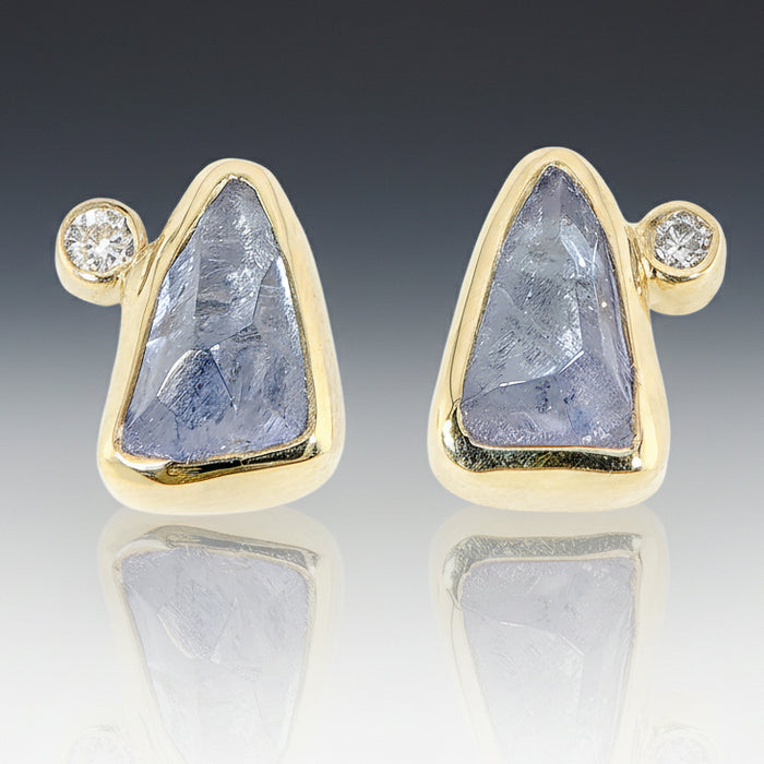 A pair of 18k yellow gold stud earrings with Tanzanite and small diamond accents.
