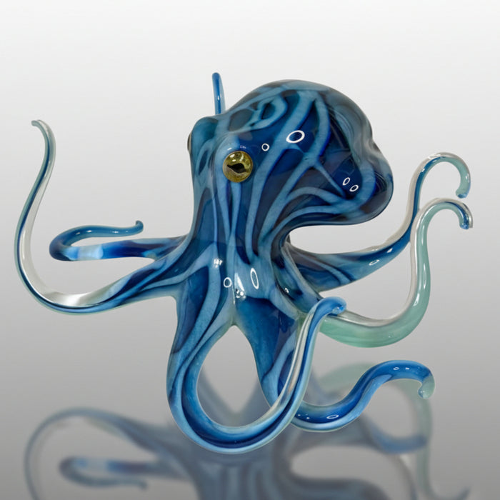 Glass sculpture of a blue octopus on a gray background