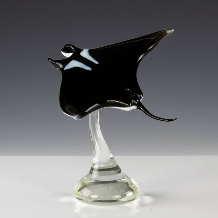 Glass sculpture of a manta ray on a white background