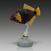 Decorative glass fish sculpture on a white pedestal against a white background