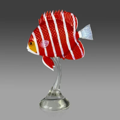 Decorative fish sculpture on a stand with a red and white striped pattern against a gray background