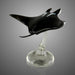 Black glass sculpture of a stingray on a gray background