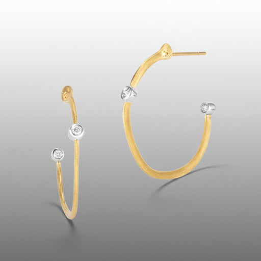 Gold hoop earrings with diamond-like stones on a gray background