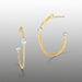 Gold hoop earrings with diamond-like stones on a gray background