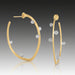 A pair of 18k white and yellow gold hoop earrings, adorned with diamonds.