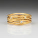 A handcrafted 18k brushed yellow gold ring with round, brilliant cut diamonds.