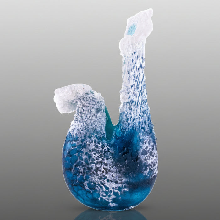 Blue and white glass sculpture on a gray background