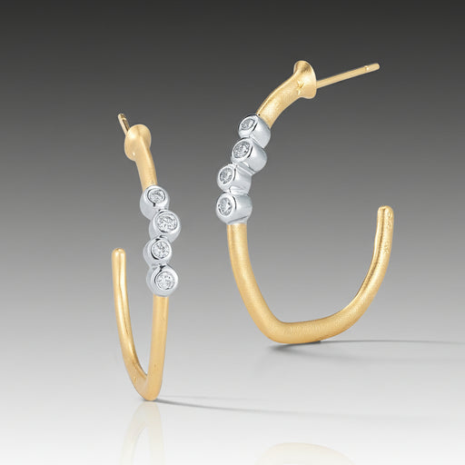 A pair of gold-colored hoop earrings with white gold accents, featuring a cluster of round brilliant-cut diamonds.
