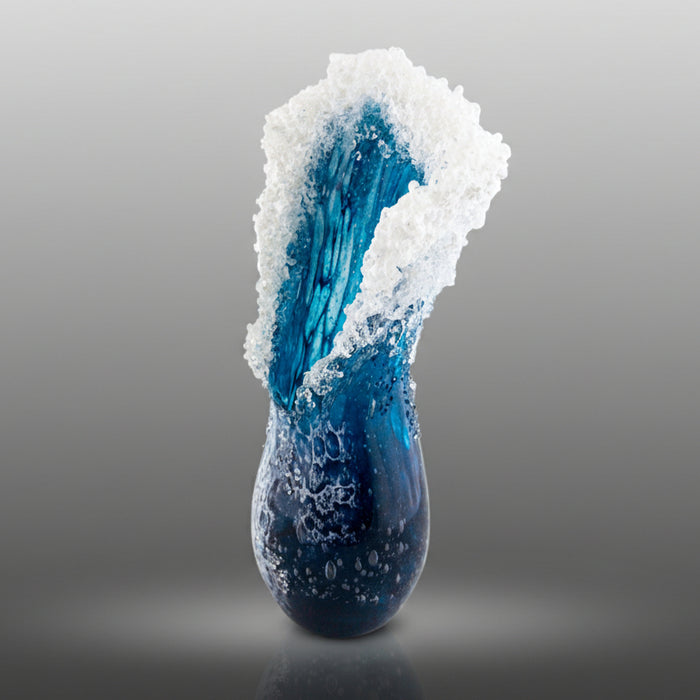 Blue glass sculpture with white crystalline structure on a gray background