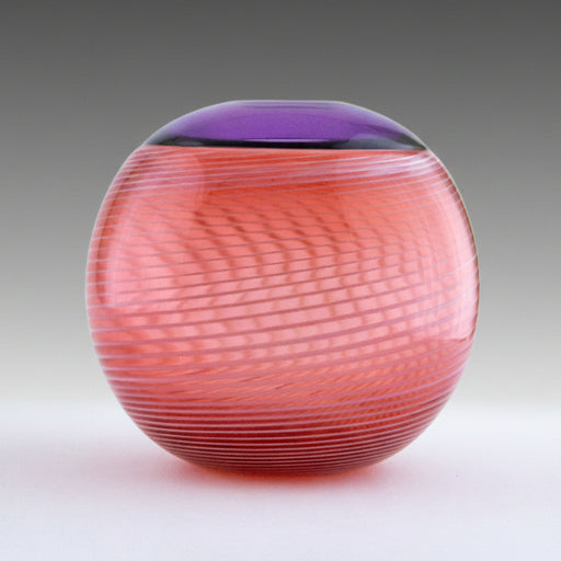 A round salmon pink blown glass vase with a white cane spiral pattern and a purple Incalmo rim.