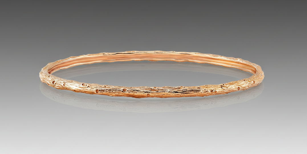 A textured gold bracelet with a solid pattern, likely made from 18k rose gold, as part of Aaron Henry's Signature Arbor Collection.