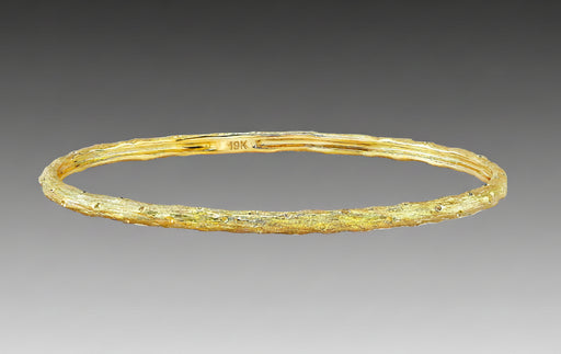 A textured gold bracelet with a solid pattern, likely made from 19k yellow gold, as part of Aaron Henry's Signature Arbor Collection.