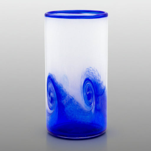 A hand blown blue glass tumbler with a wave-like pattern.