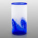 A hand blown blue glass tumbler with a wave-like pattern.
