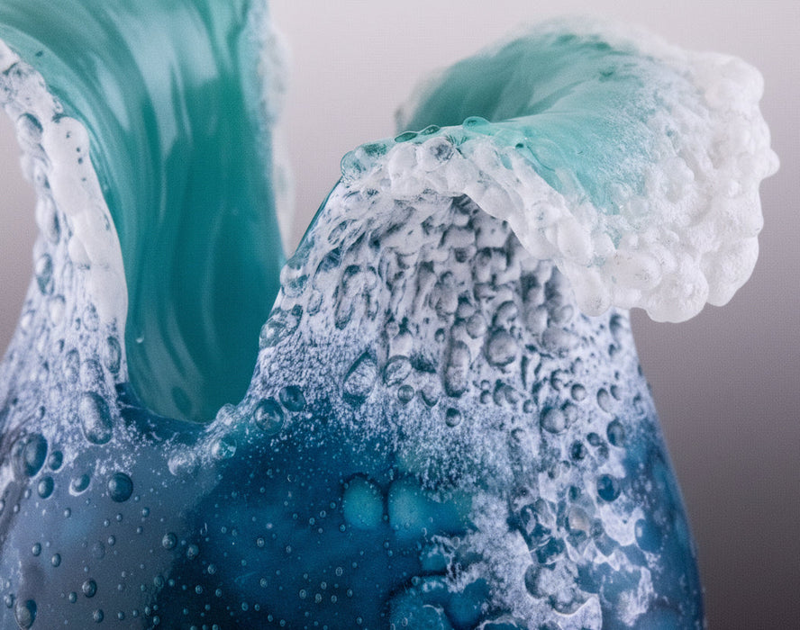 Close-up of swirling blue and white liquid with bubbles of glass sculpture vase